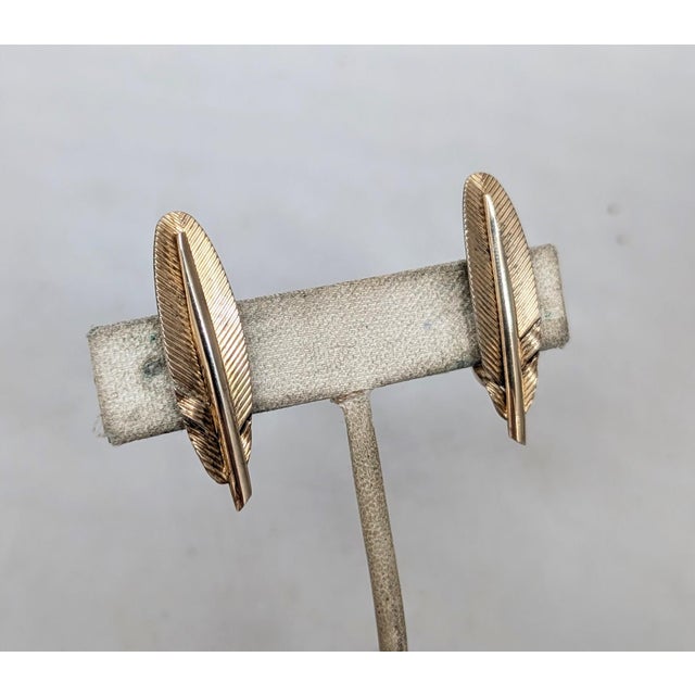 Circa 1960s goldtone over sterling feather clip earrings. Marked "NAPIER STERLING" along the inside of the clips. Measure:...
