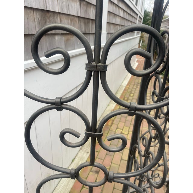 A striking, architectural hand-forged iron screen with elegant scrollwork, substantial weight, and indoor-outdoor...