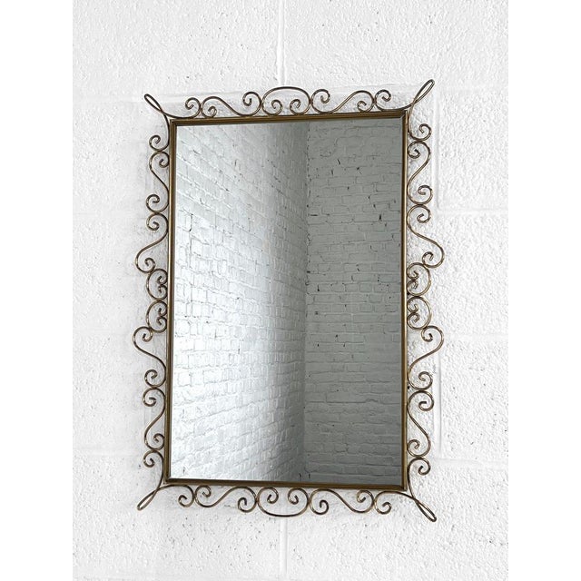 Rectangular mirror from the 1950s-60s with a brass frame adorned with scrolls. Beautifully crafted and in excellent...