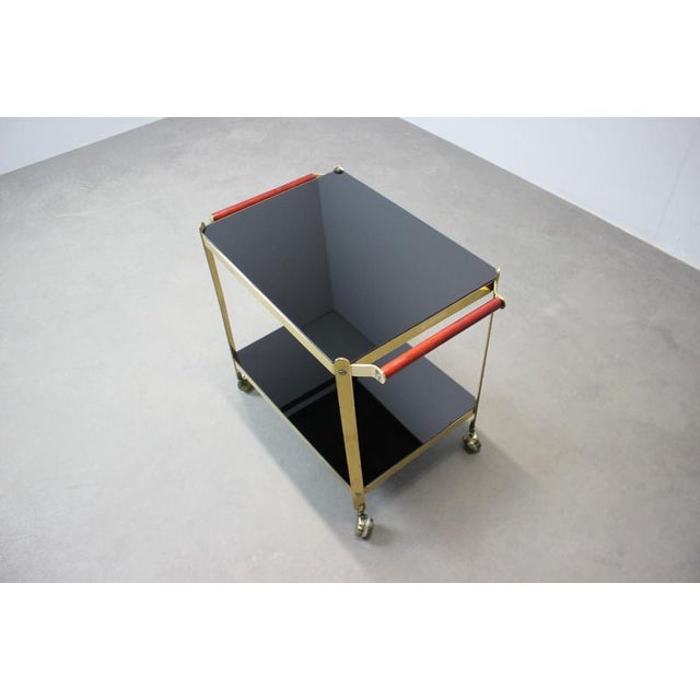 Mid-Century Modern serving trolley manufactured in Germany during the 1970s. The design features a solid brass frame,...