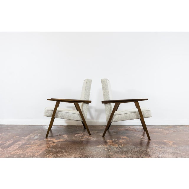 A pair of armchairs, manufactured in Poland in the 1960s. This model is characterised by light proportions, contrasting...