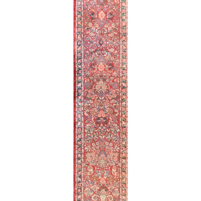 This early 20th-century Persian Sarouk runner is a stunning example of the vibrant, finely woven rugs that emerged from...