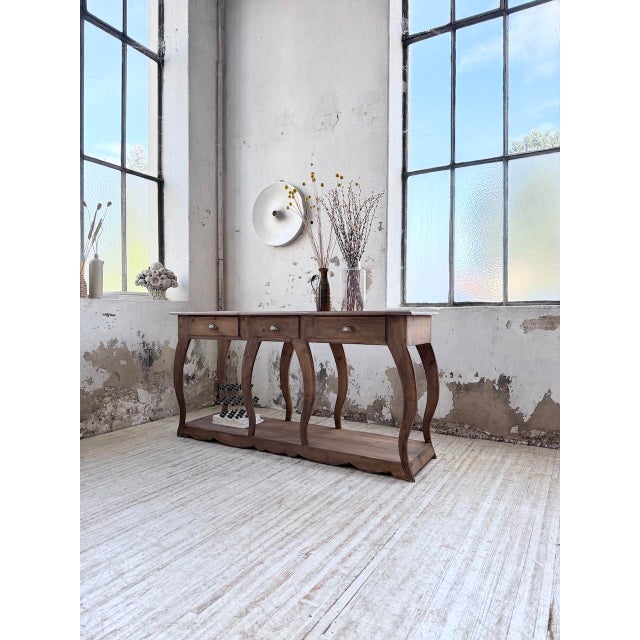 Antique console table, in the style of a draper's table from the 1950s. we love its unique shape and the curve of its...