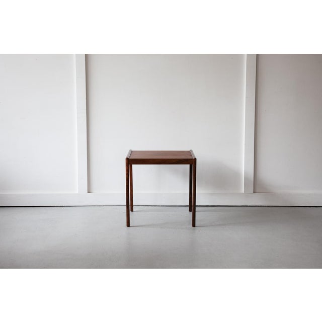 A smart and stylish rosewood side table from Denmark, rectangular in shape, featuring a lovely grain on its top and...