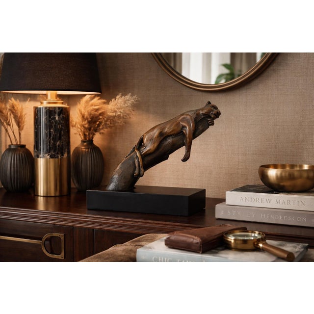 Striking vintage sculpture depicting a reclining panther draped over a naturalistic tree trunk, masterfully capturing both...