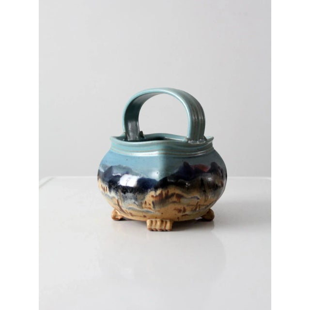 A ceramic basket by Carl Sheehan, Fire Hole Pottery, dated 1999. This hand-crafted studio piece takes the form of a...