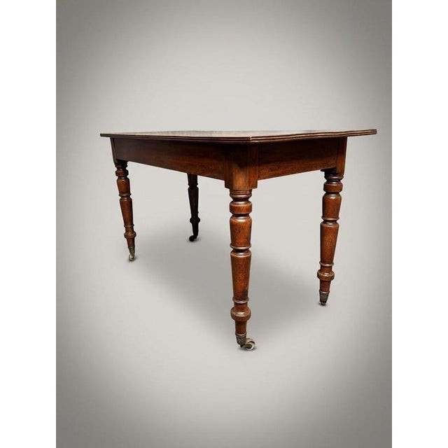 Constructed in England circa 1880, this 19th-century side table presents a well-figured flame mahogany top set above an...