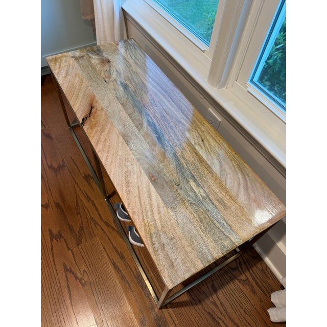 Wood and metal bench featuring a natural wood top and bronze-tone metal frame. The original finish on the wood top was...
