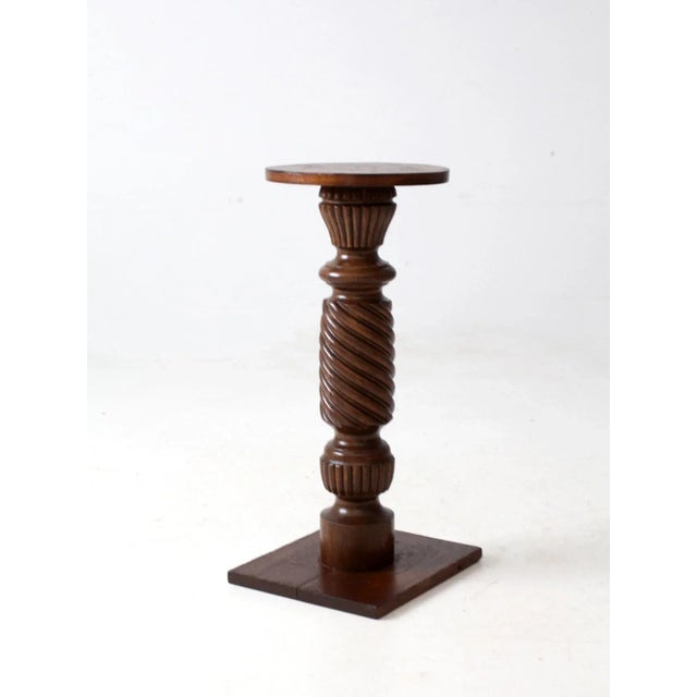 This antique American wood pedestal stand features a turned baluster column and a round top. Its classic silhouette makes...