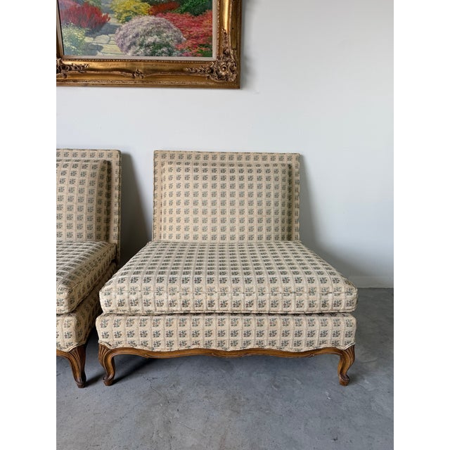 An elegant pair of 1970s Hollywood Regency armless lounge chairs in the style of John Widdicomb. These generously...