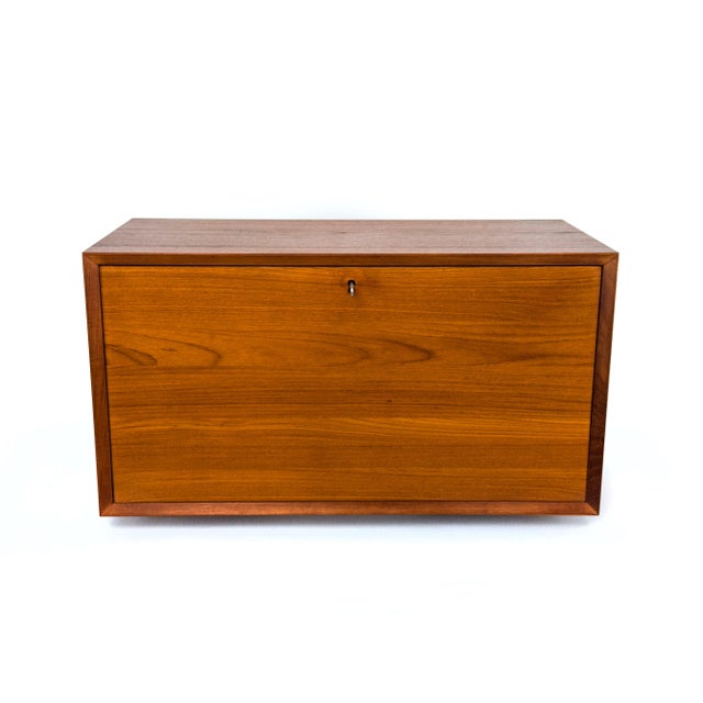 Rare wall-mounted cabinet with a front-opening flap for the Cado system, designed by Poul Cadovius. Interior with a...