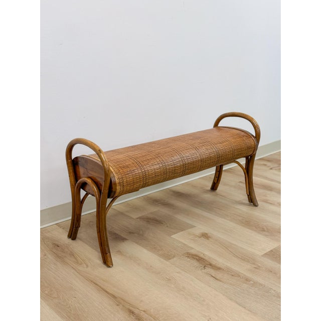 This charming vintage 1960s French style bentwood rattan and woven bench is a beautifully crafted and distinctive mid-...