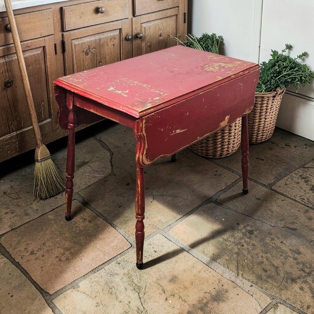 An American farmhouse gateleg drop-leaf table dating to the late 19th to early 20th century, constructed in mixed...