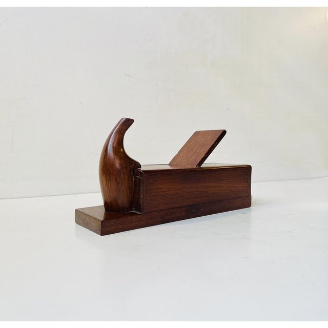 A late 19th or early 20th century decorative box or snuff box in the form of a woodworking tool, a plane. The lid part...
