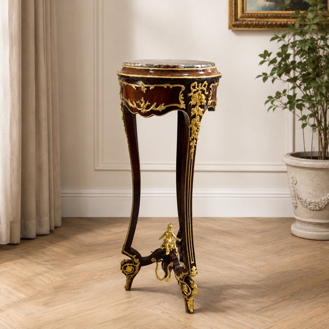 Elegant small French-style side table with a refined, slender silhouette and luxurious decorative details. The piece...