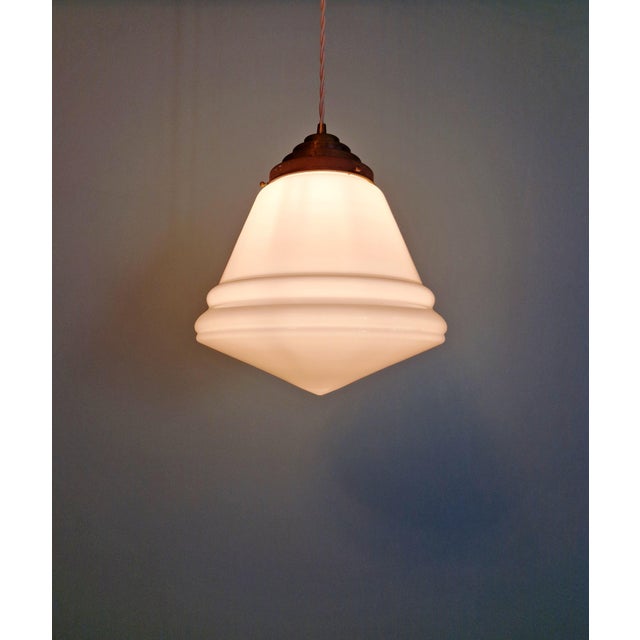 Art Deco conical pendant light in white opaline glass with a brass mount, 1920s-30s. The pendant has been rewired with a...