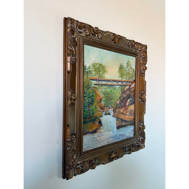 Beautiful vintage landscape oil painting by IRV Latimer featuring a scenic waterfall flowing beneath a rustic bridge....