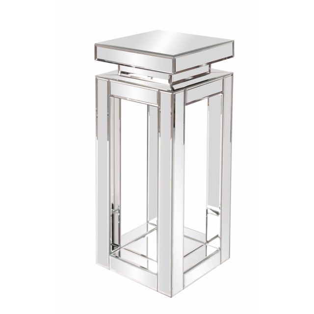 This mirrored pedestal table features a mirrored open frame body with mirrored top surface. Each mirrored panel has a...