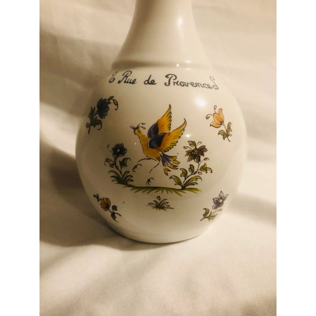 Heavily glazed bottle depicting a Nightingale surrounded by flowers. Colors of yellow purple, lavender, green, all...
