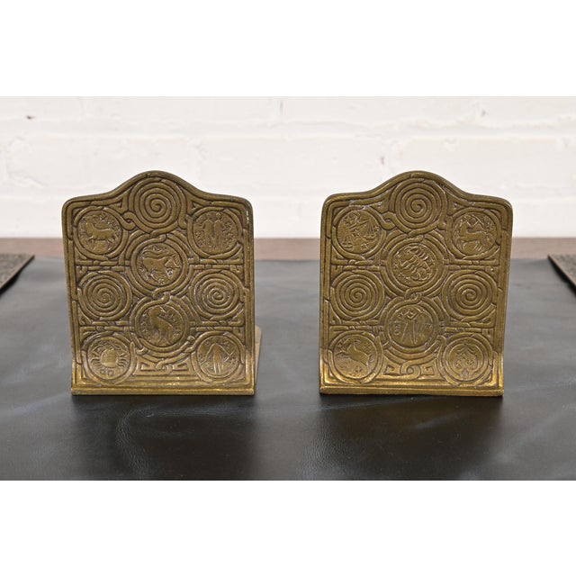 A gorgeous pair of Arts & Crafts or Art Deco period "Zodiac" pattern gilt bronze bookends By Tiffany Studios (signed to...