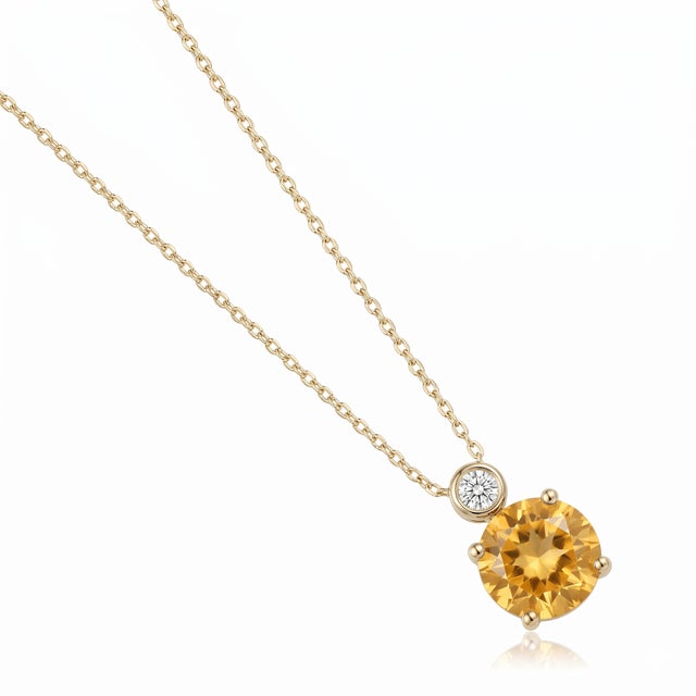 Capture the warmth of the sun with this breathtaking solitaire pendant necklace. This exquisite piece features a...