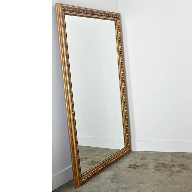 Dimensions: 68 ¾” H x 45 ¼” W x 2 ⅜” D A stunning 19th century French gold gilt mirror of thick egg & dart molding around...