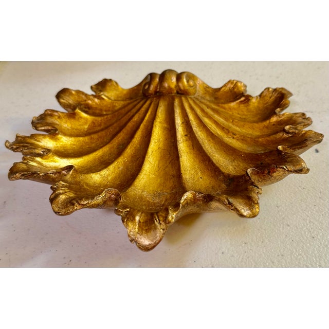 This elegant shell-shaped dish is a decorative catchall designed in the classic Florentine style, featuring a gold-leaf or...