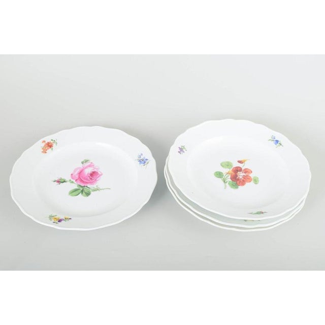 Meissen Four dinner plates, c. 1930s. Four porcelain plates, hand-painted with multicoloured floral decorations. Classic...