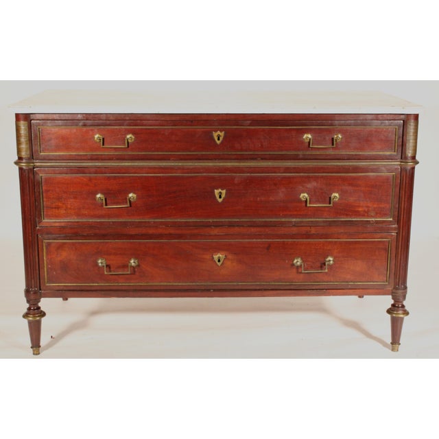 Louis XVI mahogany brass mounted chest of drawers with Carrara marble top, circa 1800. With a Carrara marble top with...