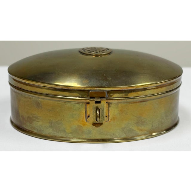 Large oval brass box featuring Asian insignia detail to domed lid. Substantial size. Nice patina. Clean interior.