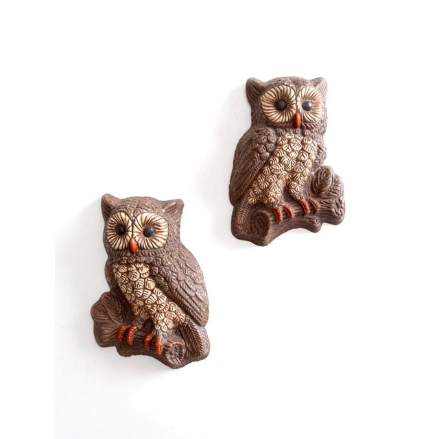 A pair of vintage 1970s owl wall plaques, molded in hard foam with richly dimensional feather detailing and a palette of...