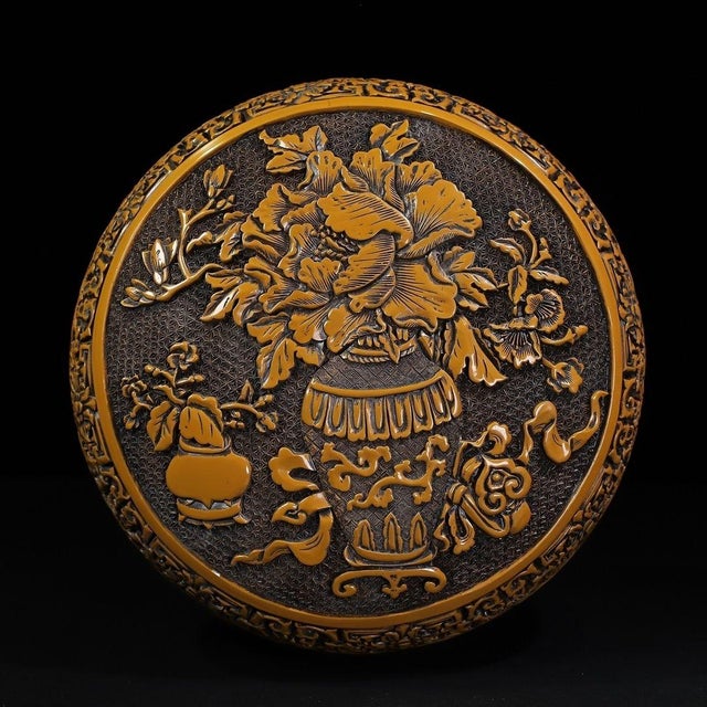 This is a striking and substantial carved lacquer box, featuring deep, intricate relief work in a vibrant, mustard-yellow...