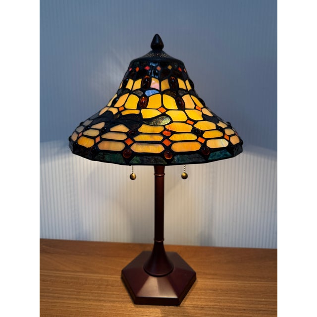 Design Plus Gallery presents a Tiffany Inspired Table Lamp. The lamp has a dark brown stem of a composite material that is...