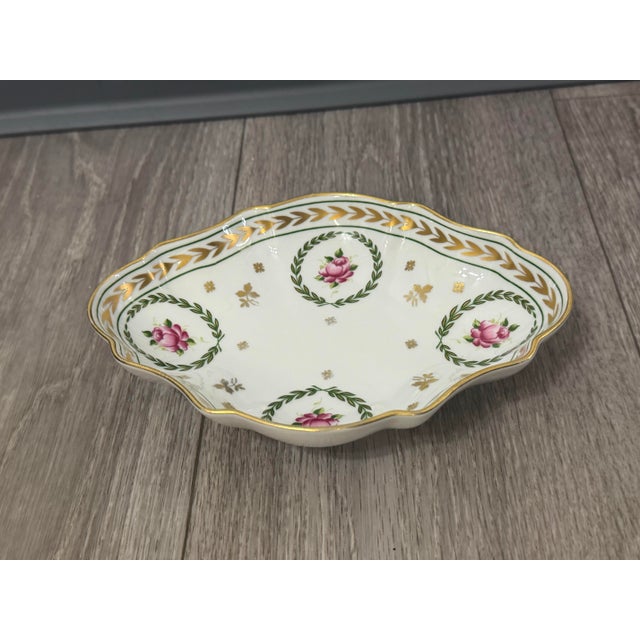 A beautifully detailed Limoges porcelain dish from the late 20th century, featuring the classic Flore wreath motif,...
