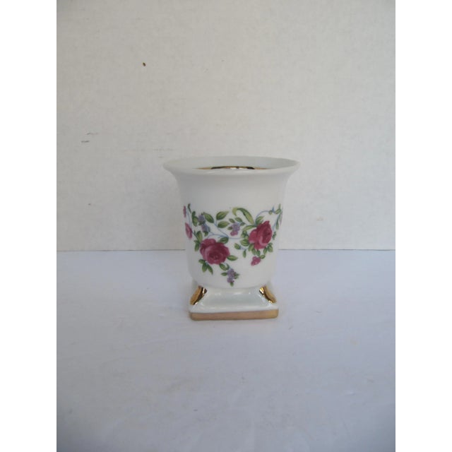 Small white porcelain urn with flowers. Could be used as a pencil cup or a container for small items. Combined shipping...
