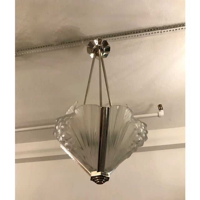 French Art Deco chandelier signed by Atelier Petitot. The three shades are in clear frosted glass with over flowing...