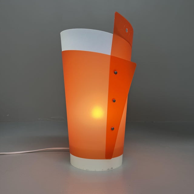 A striking italian design lamp from the 1990s, featuring a playful, sculptural silhouette and a distinctive postmodern...