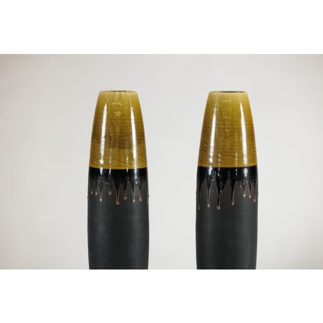 "About the Item This pair of tall artisan-made ceramic vases has a clean, architectural silhouette that suits both...
