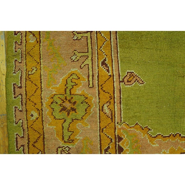 A light lime green open field is centred by a pale salmon medallion and is clasped by en suite quarter corners. The edges...