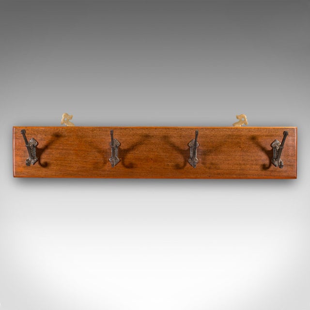 This is an antique coat rack. An English, mahogany and steel cloakroom or reception hall quartet of mounted hooks, dating...