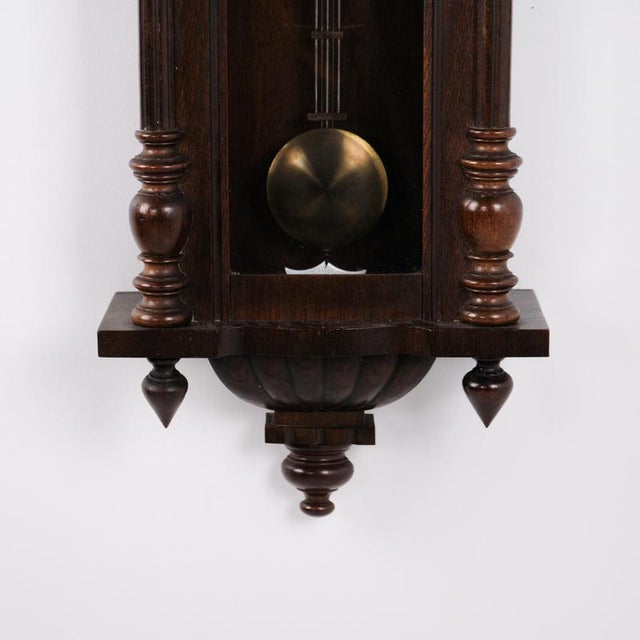 Antique wall / hanging clock by Junghans, crafted in oak from the 1920s. The clock has a classic appearance with a wooden...