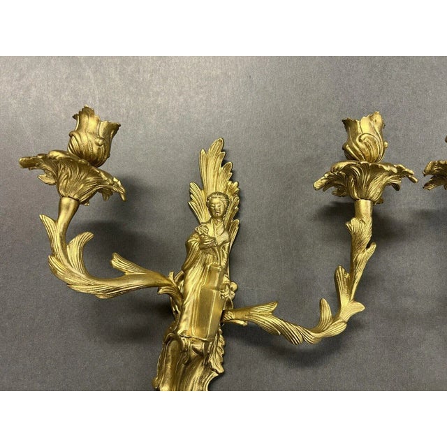 Beautiful gilt-bronze candle sconces from the Hollywood Regency era. Neoclassical detailing each with a male and female...
