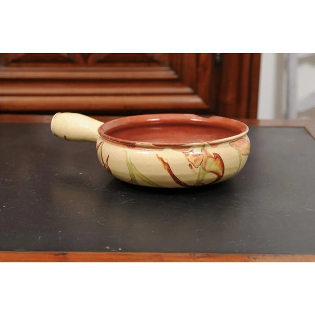 A French glazed pottery serving dish from the 19th century, with terracotta and gold glaze. Created in France during the...