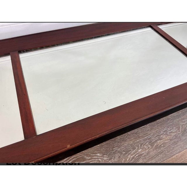 A substantial antique three-panel mantel mirror featuring original aged mirror glass set within a handsome dark brown...