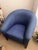This is a classic barrel-style tub chair featuring a rounded, continuous back and armrest design. It is upholstered in a...