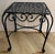 A handsome pair of French-style wrought iron side tables featuring beautifully crafted open lattice tops and elegant hand-...
