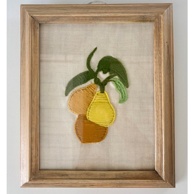 This handmade, framed textile art features a trio of embroidered pears in muted yellow, gold, and brownish tones. The...