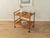 Classic serving trolley from the 1960s. Solid teak frame with two shelves in teak veneer and plastic casters. Quality...