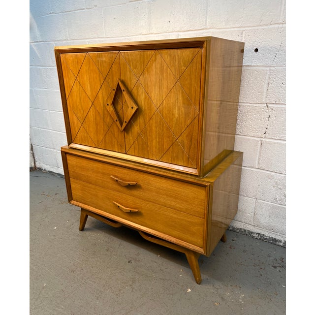 Beautiful mid-century modern gentleman’s chest featuring a striking finish, sculpted drawer pulls, and eye-catching...