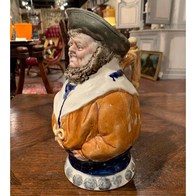 Full of humor and character, this antique barbotine pitcher takes the form of a jovial sailor standing in a confident,...